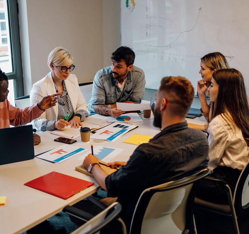 how a creative marketing agency can help grow your business creatives in a room discussing marketing strategy during meeting