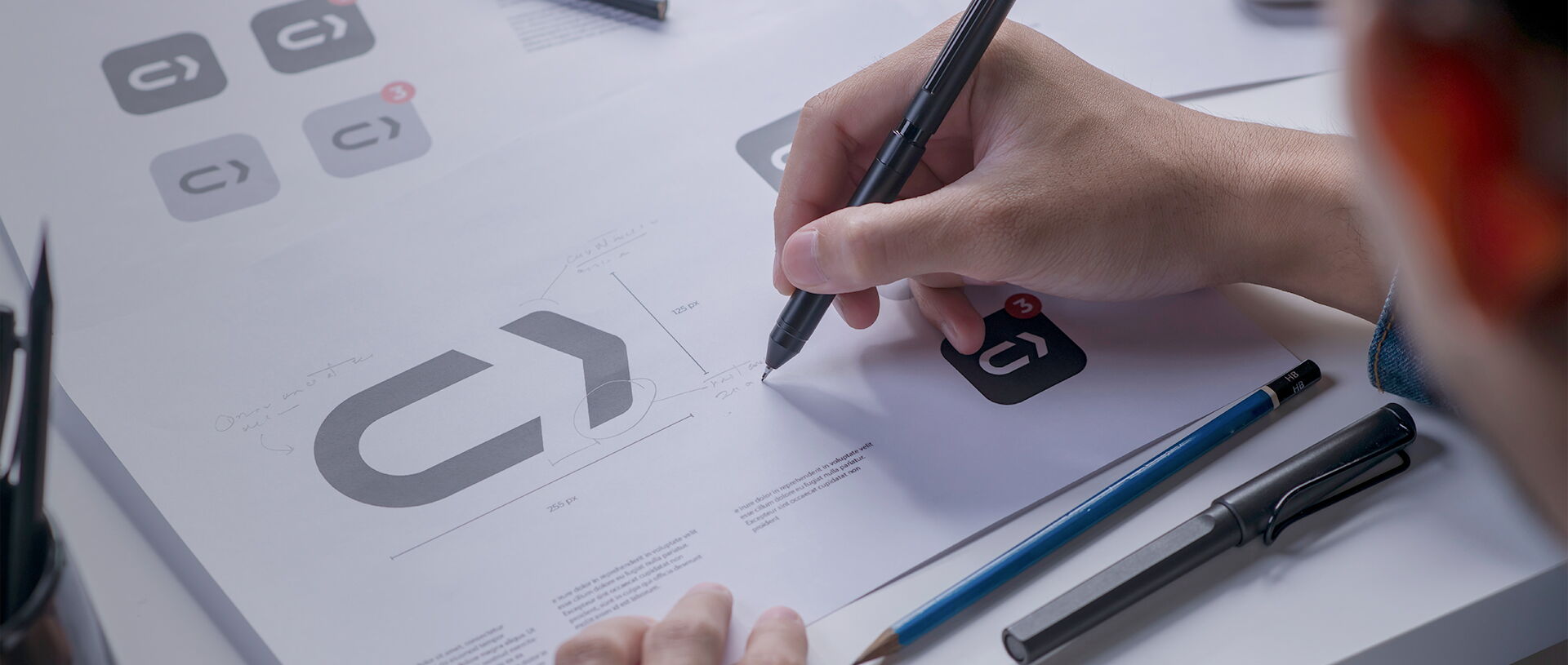 graphic designer sketching logos and icons for a tech company