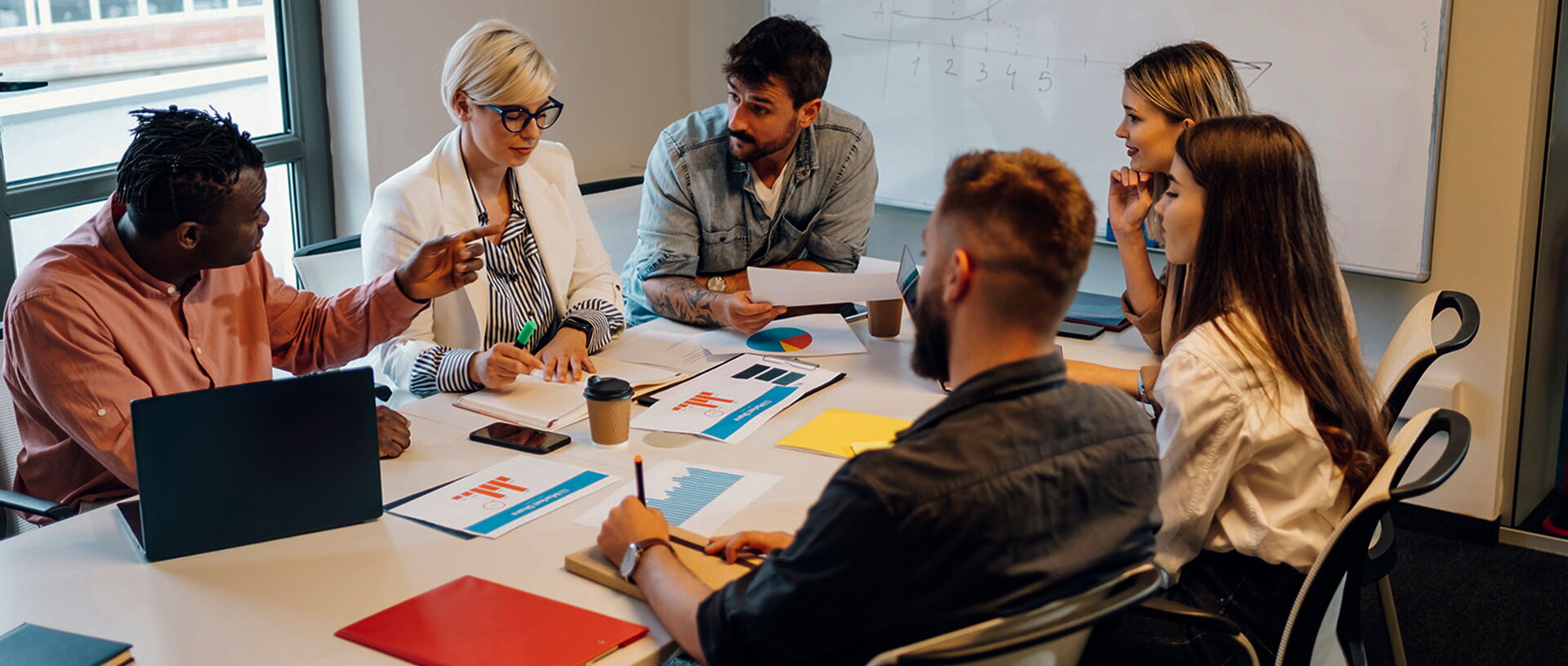 how a creative marketing agency can help grow your business creatives in a room discussing marketing strategy during meeting